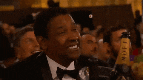 a man in a tuxedo is smiling while holding a bottle of moet champagne