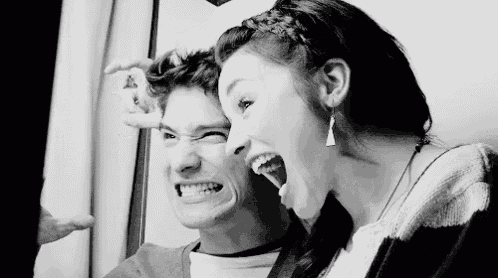 a boy and a girl are making funny faces in a black and white photo .