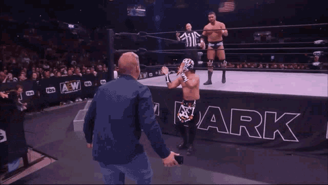 a wrestler is jumping over another wrestler in a ring that says aew