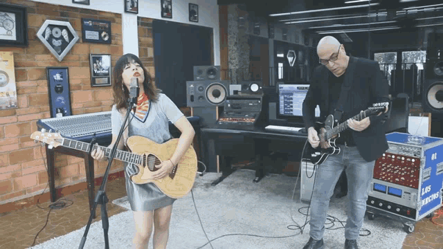 a woman sings into a microphone while a man plays guitar