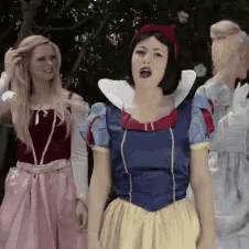 a woman in a snow white costume is standing next to another woman in a pink dress
