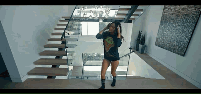 a woman standing on a set of stairs wearing a t-shirt that says ' avengers ' on it