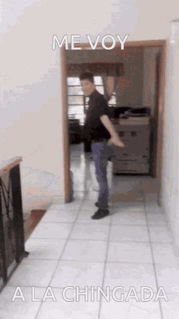a man standing in a hallway with the words me voy a la chingada