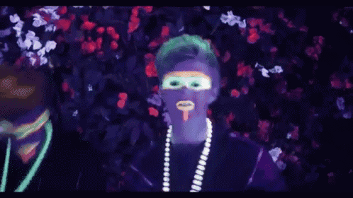 two people with glow in the dark paint on their faces are standing next to each other