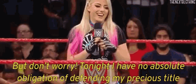 a woman in a wrestling ring is talking into a microphone .