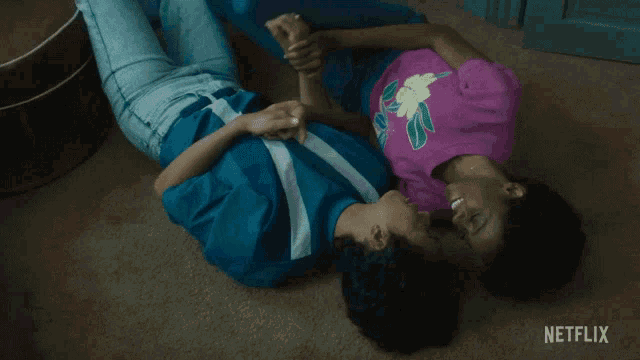 two people laying on the floor with netflix written on the bottom right