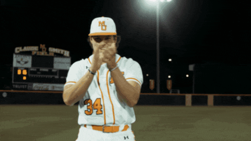 a baseball player with the number 34 on his jersey is clapping