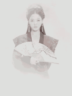 a woman in a traditional costume is holding a fan in her hands .