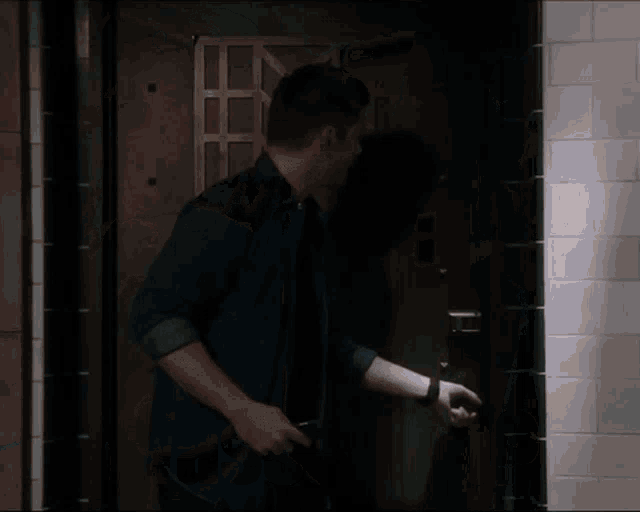 a man with a surprised look on his face is standing in front of a door that says wassuuup on it