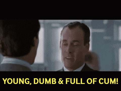 a man in a suit is talking to another man with the words young dumb & full of cum above him