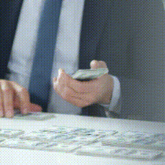 a man in a suit and tie is using a cell phone