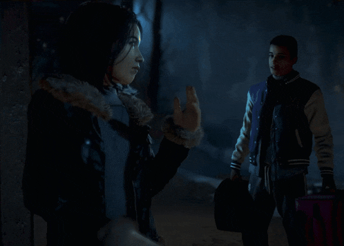 a man and a woman are walking in a dark room