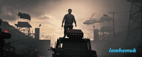 a man is standing on top of a vehicle with a helicopter in the background