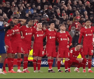 a group of soccer players wearing red uniforms with the word santander on them