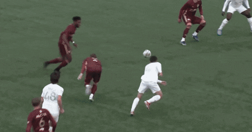a soccer goalie is diving to catch a ball in front of a banner that says ' kk ' on it