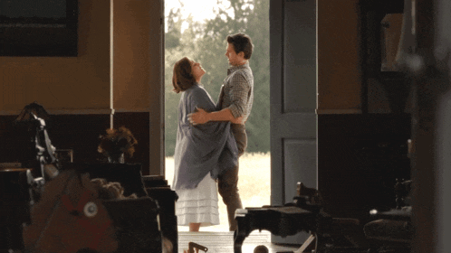 a man and woman are dancing in a room with a piano in the background