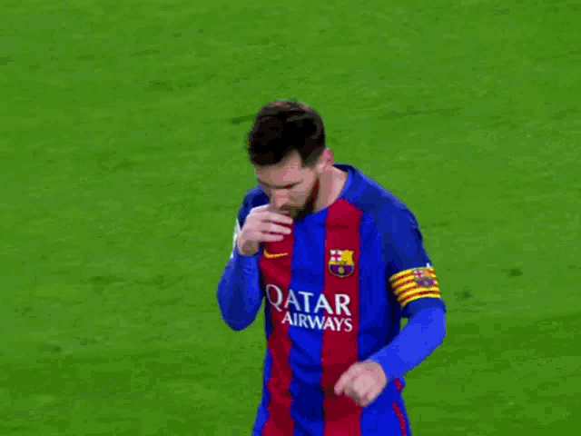 a soccer player wearing a blue and red qatar airways jersey
