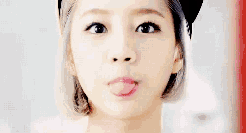 a young woman is sticking her tongue out .