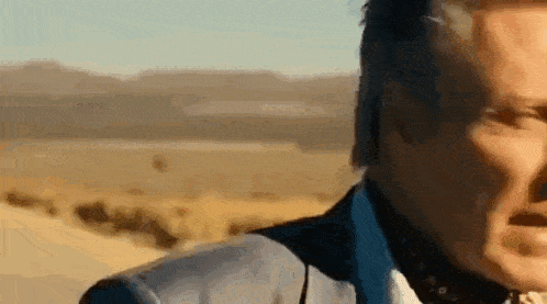 a close up of a man 's face in a desert .