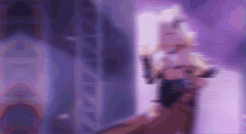 a blurry picture of a person standing in front of a purple background