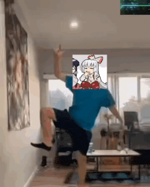 a man in a blue shirt is dancing in a living room with a picture of a girl on his back .