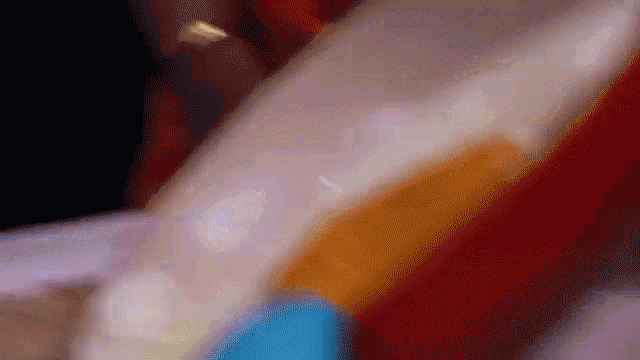 a close up of a person holding a plastic container with a yellow liquid in it .