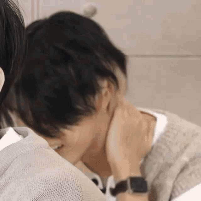 a close up of a person holding another person 's neck while wearing a watch .
