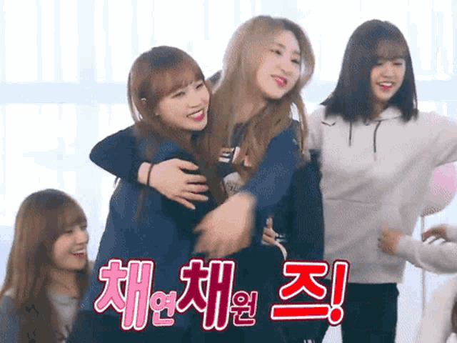 a group of girls are hugging each other in a room with korean writing on the bottom