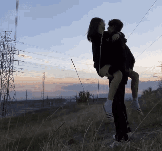 a man is carrying a woman on his back in a field
