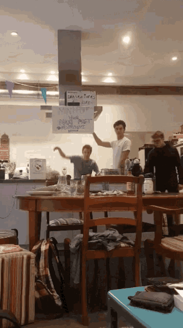 a man is holding up a sign that says " can you turn off the stove "