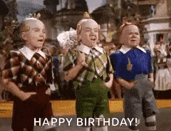 a group of three dwarfs are dancing in a parade and saying `` happy birthday '' .