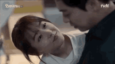 a man and a woman are kissing each other in a room .