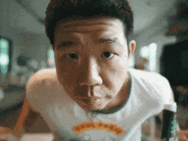 a man wearing a t-shirt that says " fool for " looks at the camera