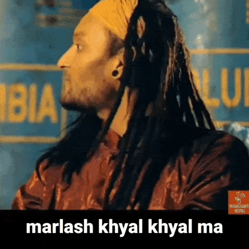 a man with dreadlocks is wearing a headband and a red shirt .