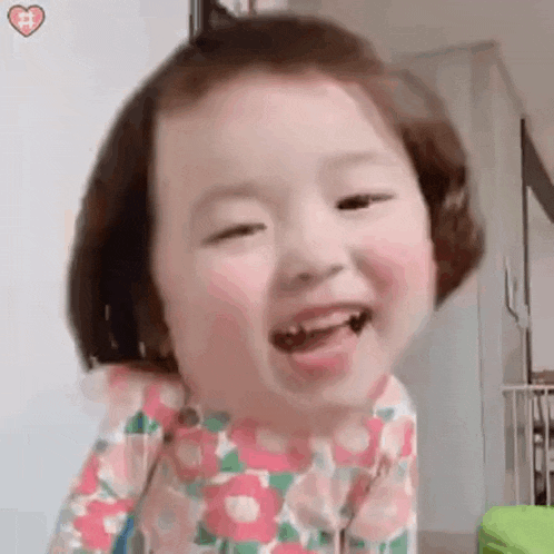 a little girl is making a funny face with her mouth open and her tongue out .