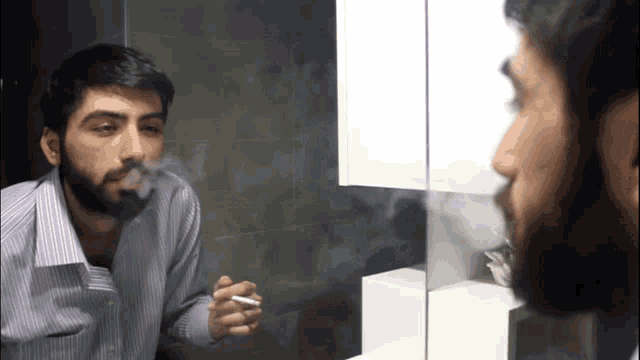 a man with a beard is smoking in front of a mirror