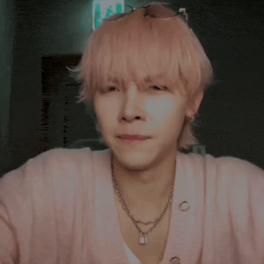 a young man with pink hair wearing sunglasses and a necklace