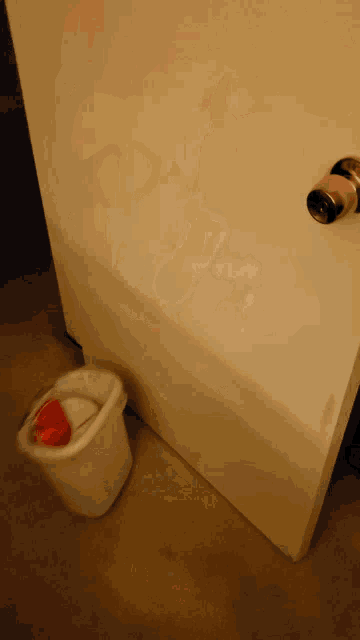 a blurred image of a person standing next to a white trash can