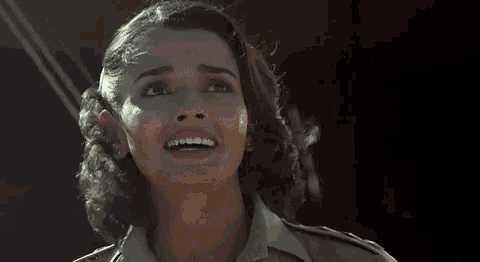 a woman is laughing with her arms outstretched in a close up of her face .