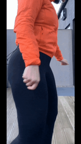 a woman in a red jacket and black pants is dancing