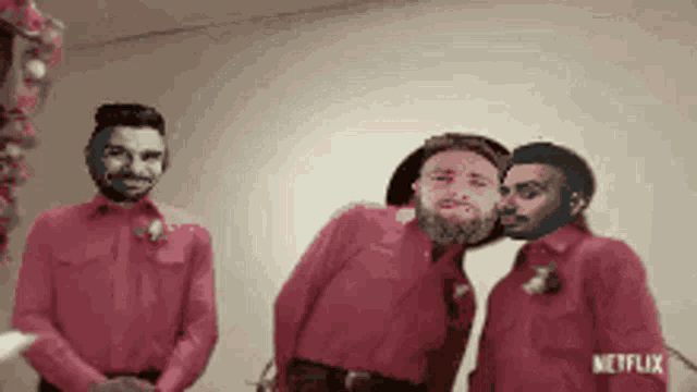 a group of men in red shirts are standing next to each other with a netflix logo in the background