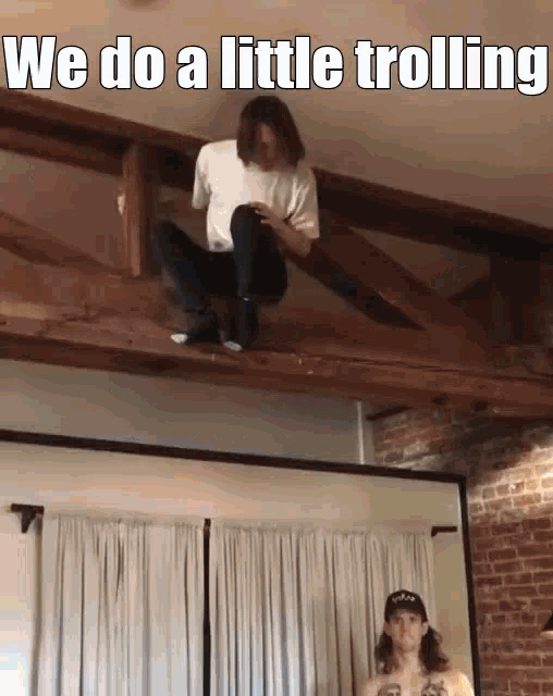 a man is sitting on a wooden beam with the words we do a little trolling above him