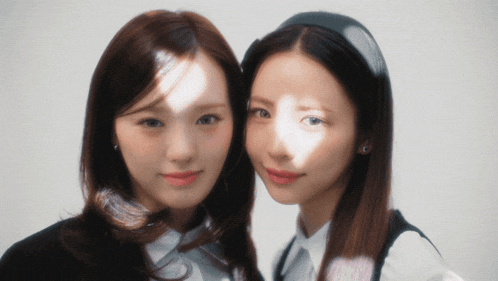 two women are posing for a picture and one has a headband on her head