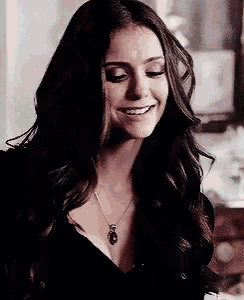 a woman is wearing a necklace and smiling .