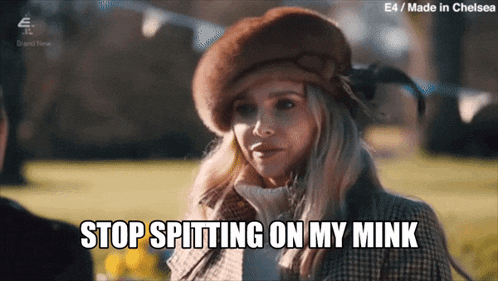 a woman wearing a fur hat and coat says stop spitting on my mink