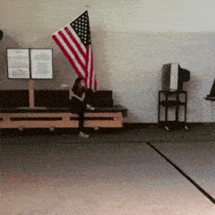 a woman sits in front of an american flag