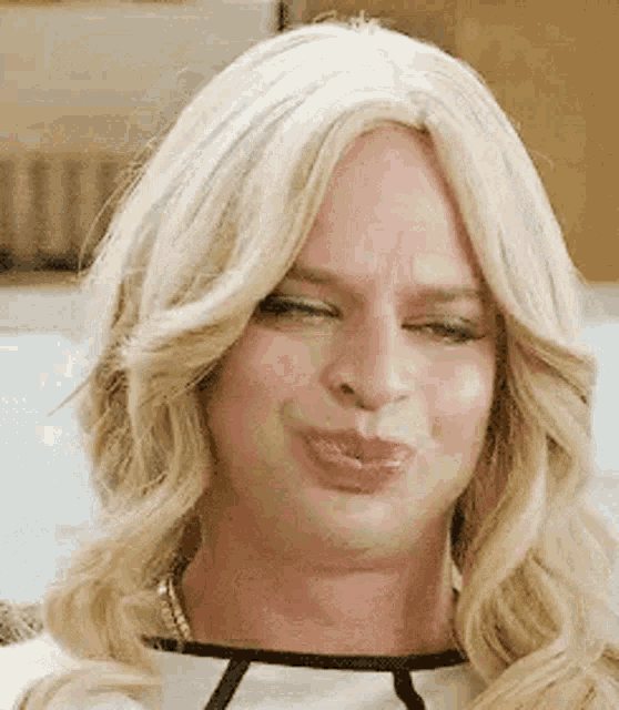 a woman in a wig is blowing a kiss .