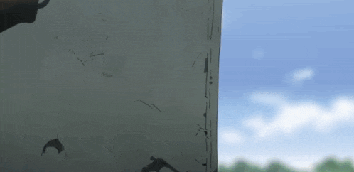 a person is standing in front of a gray wall with a blue sky in the background .