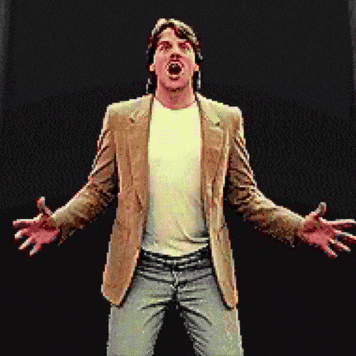 a man in a brown jacket and white shirt is standing with his arms outstretched