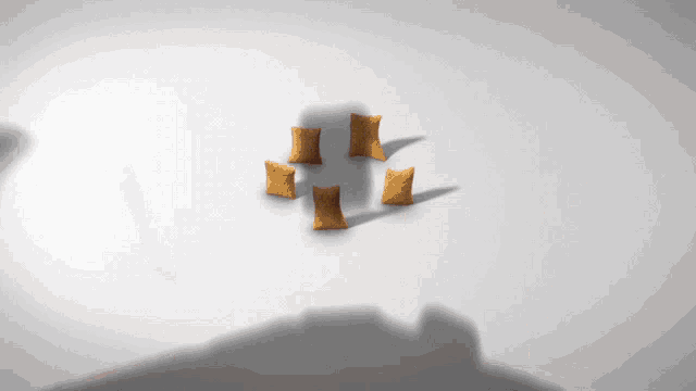 a shadow of a person is cast on a white surface with a few pieces of food in the shape of a cross